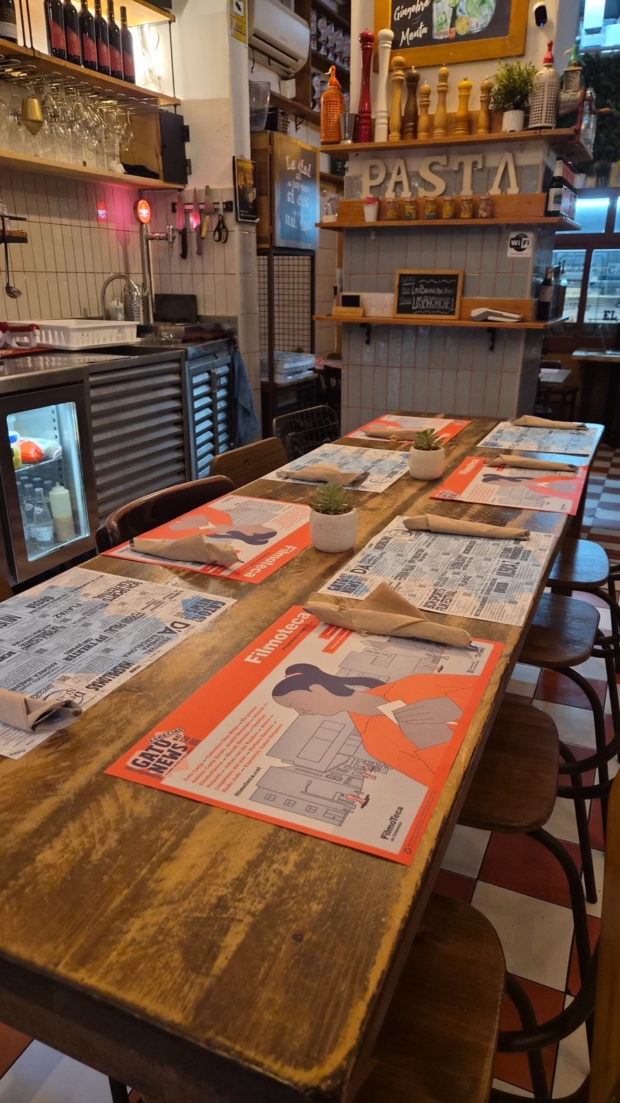 Manteles monográficos de Gato News en la mesa larga de un restaurante