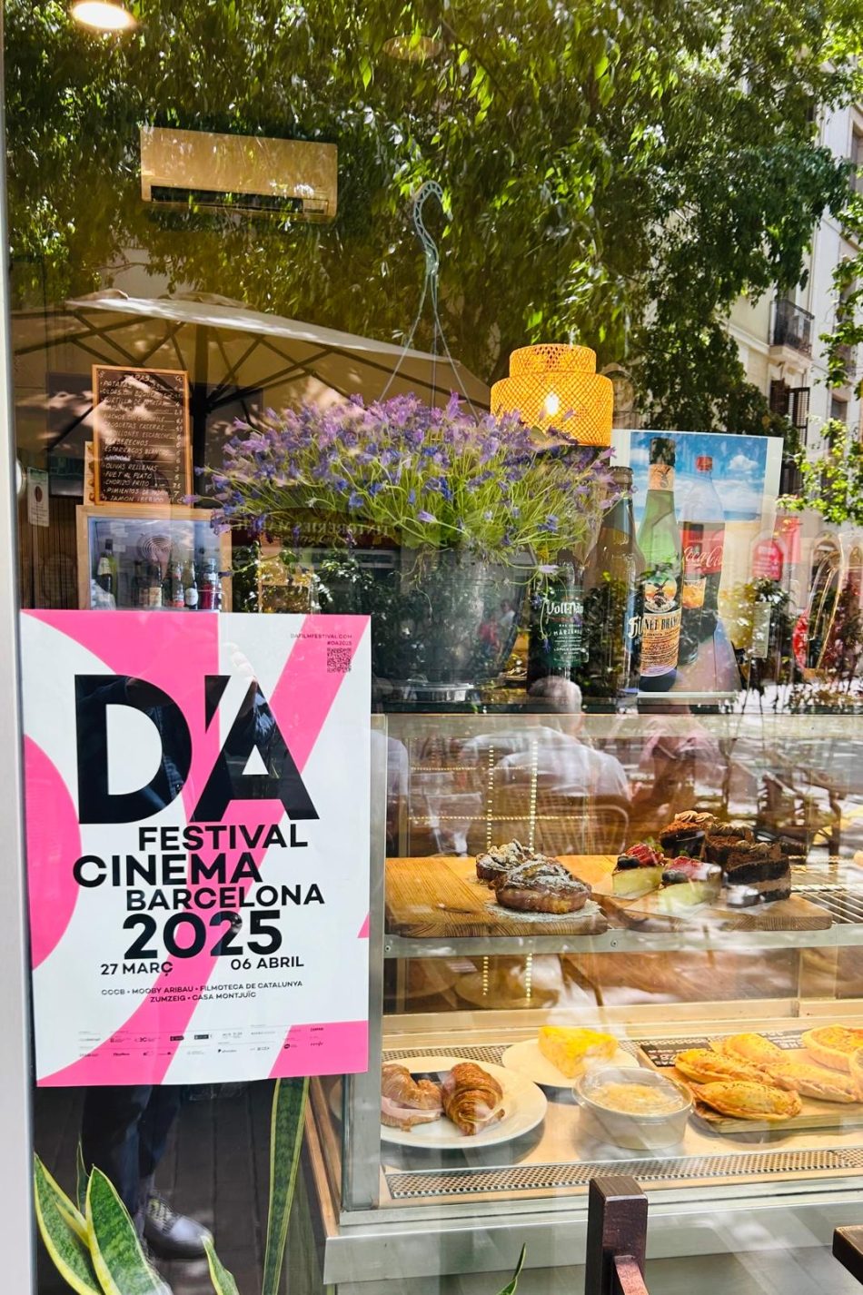 Cartel del D'A Festival pegado en el escaparate de un comercio de Barcelona